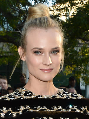 BEST BUN: Diane Kruger: We love Kruger's top knot and loose strands. Frankly, this woman can do no wrong.  To create a similar look, flip hair upside down and tie into a high ponytail at the crown of your head. Flip upright and wrap hair into a bun around the elastic. Use a pair of spin pins for extra hold before pinning the style into place with bobby pins. photo credit: George Pimentel