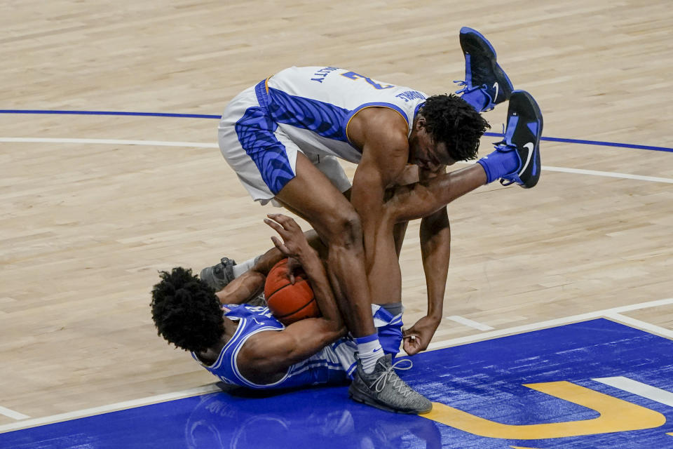 Pittsburgh's Femi Odukale (2) and Duke's Jeremy Roach scramble for a loose ball during the second half of an NCAA college basketball game Tuesday, Jan. 19, 2021, in Pittsburgh. (AP Photo/Keith Srakocic)