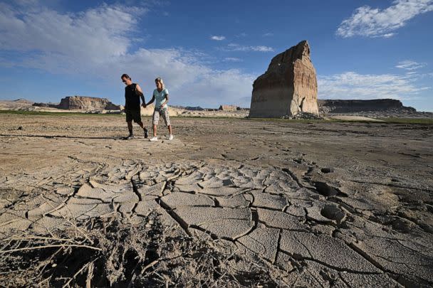 PHOTO: A couple walks past Lone Rock in Big Water, Utah, Sept. 2, 2022.  (Robyn Beck/AFP via Getty Images)