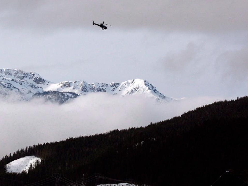 A helicopter flies near McBride, B.C., after five snowmobilers died in a major avalanche in January 2016. Avalanche Canada is warning this year may be the worst year for avalanches since 2003.  (Darryl Dyck/Canadian Press - image credit)