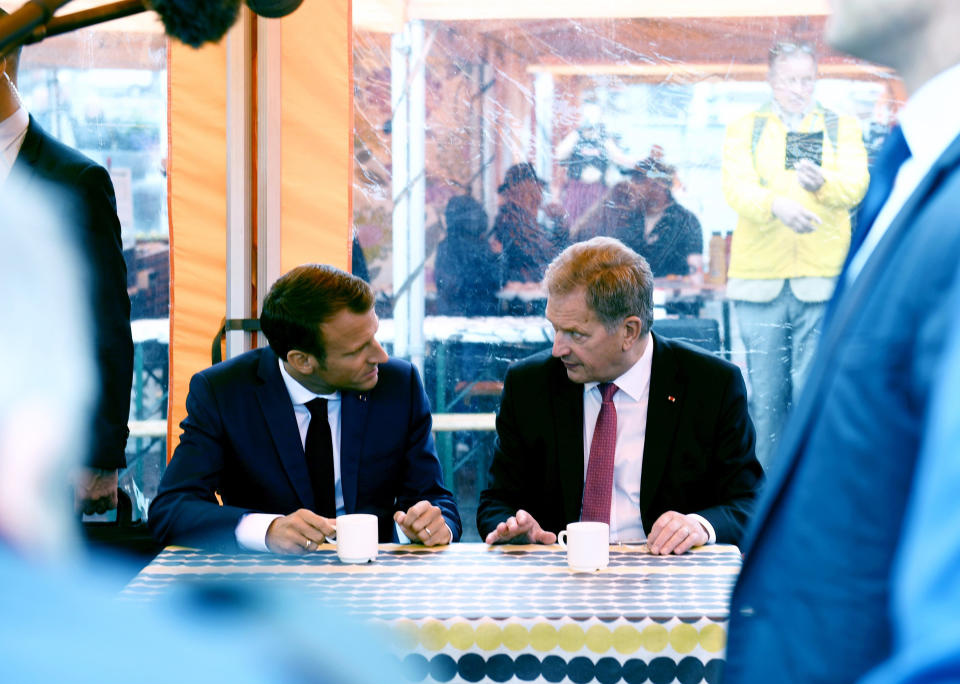 France's President Emmanuel Macron, left and Finland's President Sauli Niinisto stop for coffee at a local market, outside the Presidential Palace after their joint press conference in Helsinki, Finland, Thursday Aug. 30, 2018. Macron is in Finland on a two-day official visit. (Antti Aimo-Koivisto/Lehtikuva via AP)