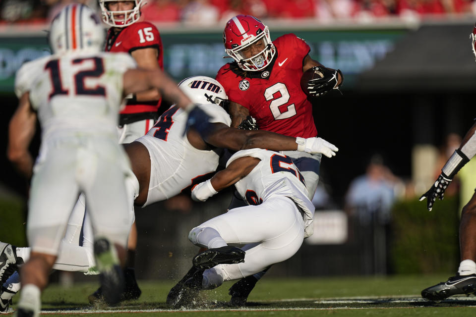 Georgia running back Kendall Milton (2) is brought down by Tennessee-Martin defensive tackle Jarid Johnson (44) and safety Robert Daniel Jr. (22) during the first half of an NCAA college football game Saturday, Sept. 2, 2023, in Athens, Ga. (AP Photo/John Bazemore)