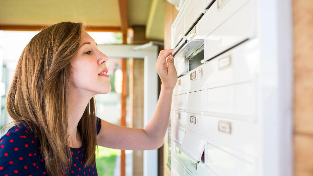 girl looking in mail box for mail