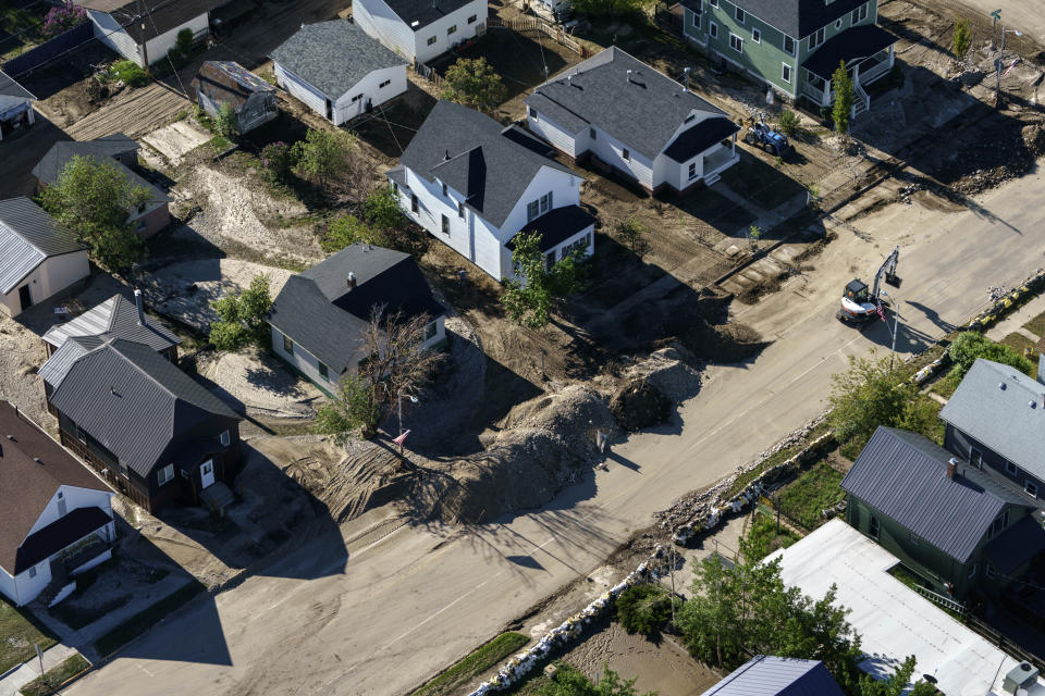 Crews work to fill in sections of residential streets washed away by recent floodwaters in Red Lodge, Mont., Thursday, June 16, 2022. (AP Photo/David Goldman)