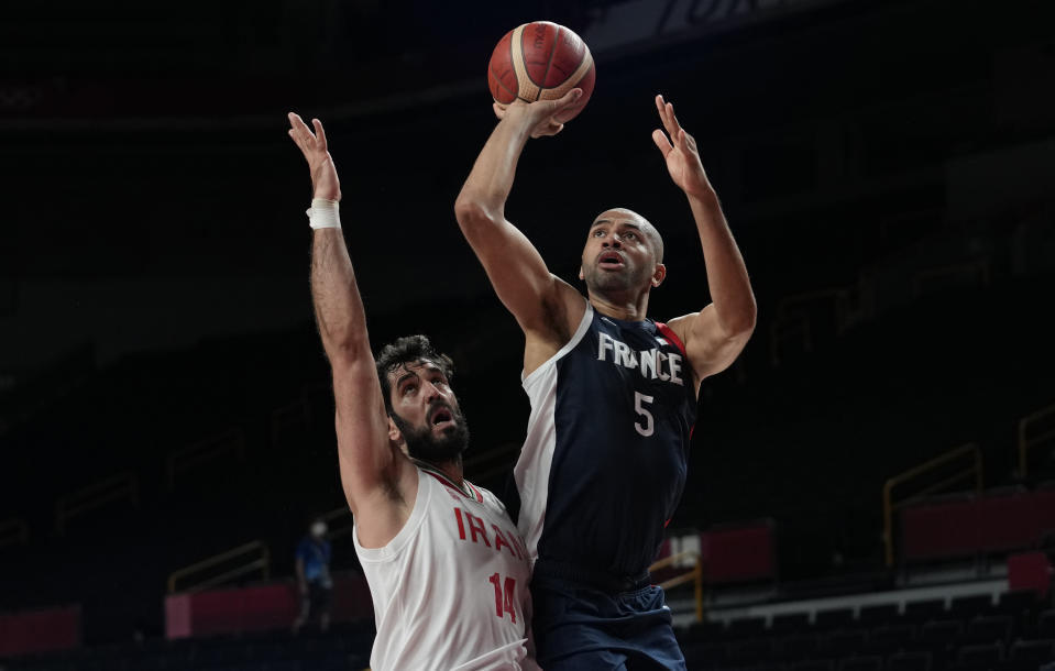 France's Nicolas Batum (5), right, shoots over Iran's Mohammadsamad Nik Khahbahrami (14) during men's basketball preliminary round game at the 2020 Summer Olympics, Saturday, July 31, 2021, in Saitama, Japan. (AP Photo/Eric Gay)