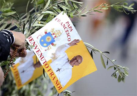 A faithful holds a flag with a picture of Pope Francis as the Pope leads the Palm Sunday mass in Saint Peter's Square at the Vatican April 13, 2014. REUTERS/Alessandro Bianchi