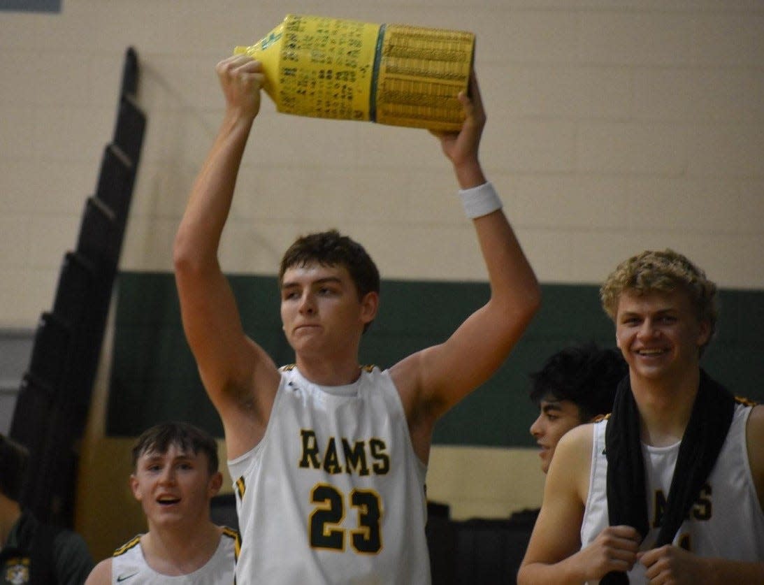 Flat Rock's Graham Junge holds up The Jug travelling trophy after Flat Rock beat Airport last season.