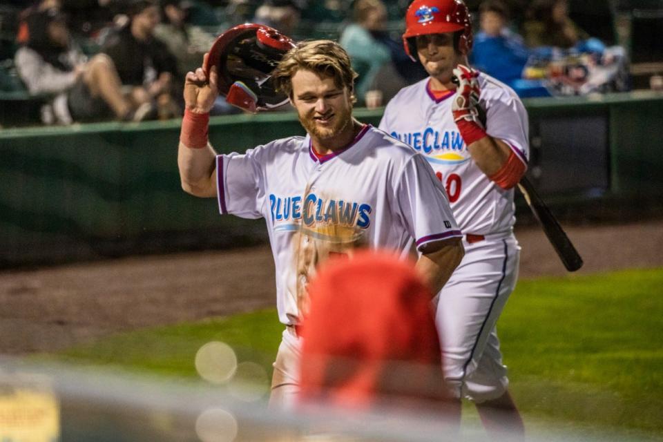 BlueClaws outfielder Ethan Wilson takes off his helmet and makes his way back to the dugout.