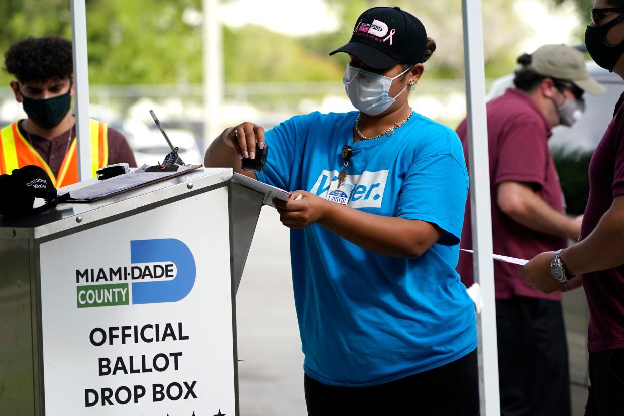 An election worker stamps a vote-by-mail ballot dropped off by a voter before placing it in an official ballot drop box (AP)