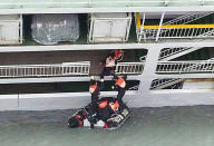 In this photo released by the South Korean Coast Guard via Yonhap News Agency, South Korean coast guard officers rescue passengers from a sinking ferry off the southern coast near Jindo, south of Seoul, South Korea, Wednesday, April 16, 2014. A ferry carrying 459 people, mostly high school students on an overnight trip to a tourist island, sank off South Korea's southern coast on Wednesday, leaving nearly 300 people missing despite a frantic, hours-long rescue by dozens of ships and helicopters. (AP Photo/South Korea Coast Guard via Yonhap) KOREA OUT