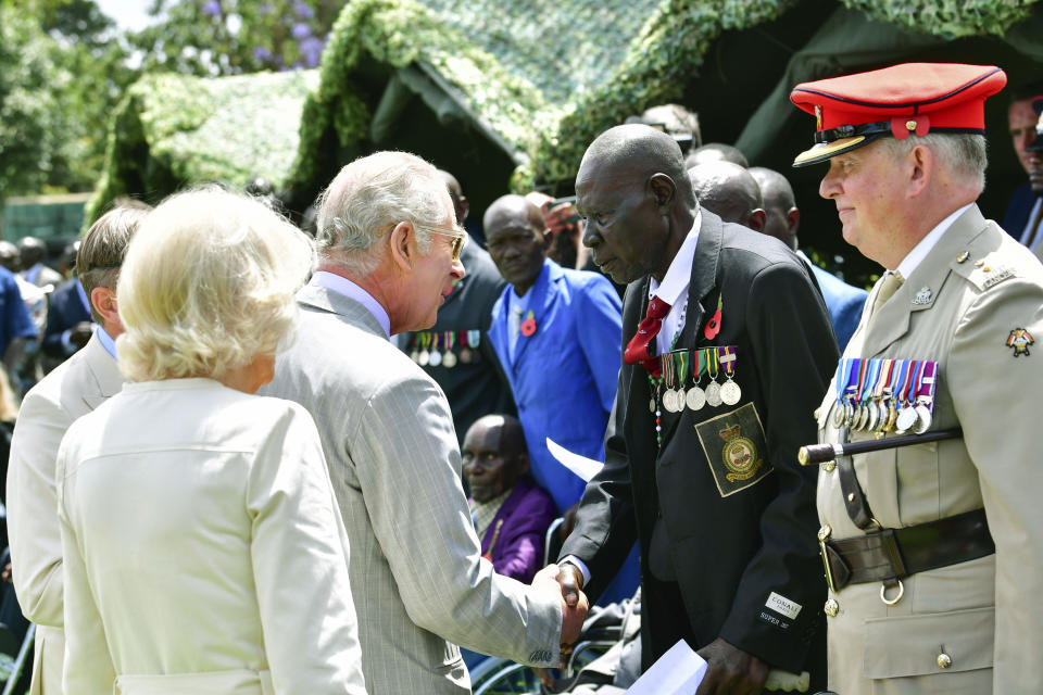 Britain's King Charles III and Queen Camilla, meets Kenyan war veteran Michael Deya, 2nd right, during a visit to Kariokor World War II Commonwealth Cemetery in Nairobi, Kenya, Wednesday, Nov. 1, 2023. King Charles III has visited a war cemetery in Kenya, laying a wreath in honor of Kenyans who fought alongside the British in the two world wars. It came a day after the British monarch expressed “greatest sorrow and the deepest regret” for the violence of the colonial era. He gave replacement medals to four war veterans. (Tony Karumba/Pool Photo via AP)