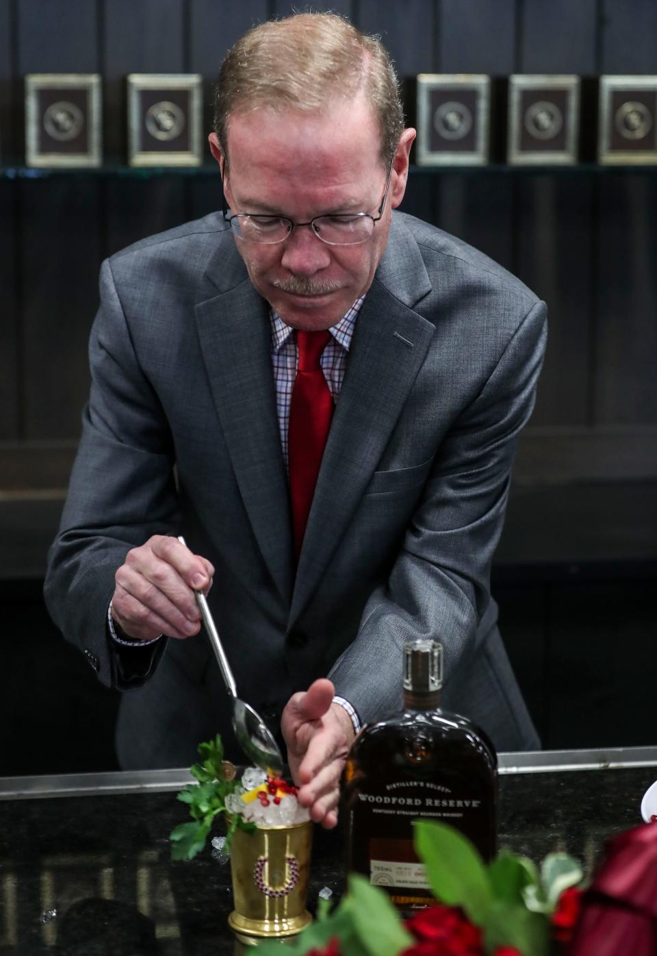 Woodford Reserve master distiller Chris Morris freshens up a 'French Minut Julep' that has pomegranate arils in a $2,500 Mint Julep cup that will be for sale on Derby Day at Churchill Downs. A $1,000 silver cup will also be for sale. Proceeds will benefit Old Friends Farm, where racing thoroughbreds are sent to retire, including past Kentucky Derby Winners.