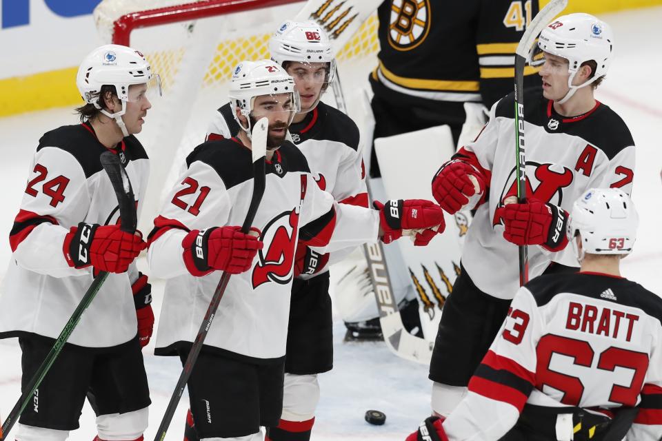 New Jersey Devils' Kyle Palmieri (21) celebrates his goal with teammates Ty Smith (24), Jack Hughes (86), Damon Severson (28) and Jesper Bratt (63) during the first period of an NHL hockey game against the Boston Bruins, Sunday, March 28, 2021, in Boston. (AP Photo/Michael Dwyer)