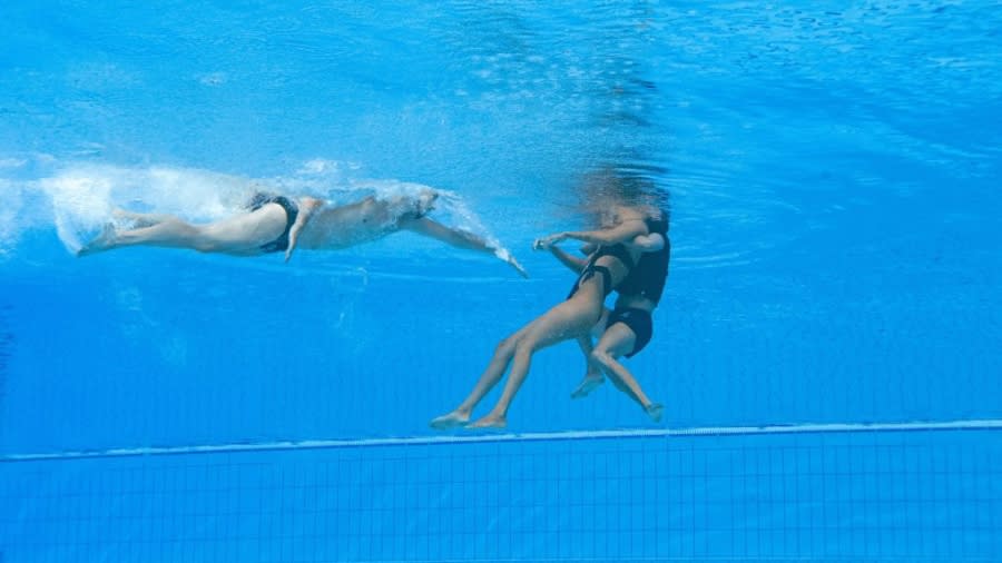 Anita Alvarez is retrieved from the pool by coach Andrea Fuentes during the 2022 FINA World Championships. (Oli Scarff/AFP via Getty Images)