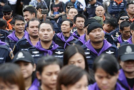 A riot police takes pictures while standing guard as anti-government protesters break down the barriers at the Thai Police Headquarters in Bangkok December 4, 2013. REUTERS/Dylan Martinez