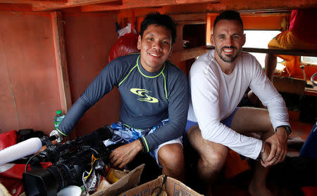 Reuters Manila bureau chief Martin Petty (R) and video journalist Peter Blaza (L) sit inside a Filipino fishing vessel sailing in Scarborough Shoal, South China Sea, April 6, 2017. REUTERS/Erik De Castro