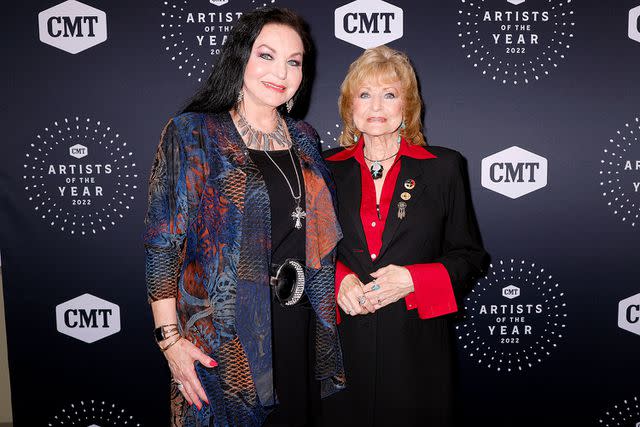 <p>Brett Carlsen/Getty</p> In this photo released on October 14, 2022, Peggy Sue Wright (L) and Crystal Gayle attend the 2022 CMT Artists of the Year at Schermerhorn Symphony Center on October 12, 2022 in Nashville, Tennessee.