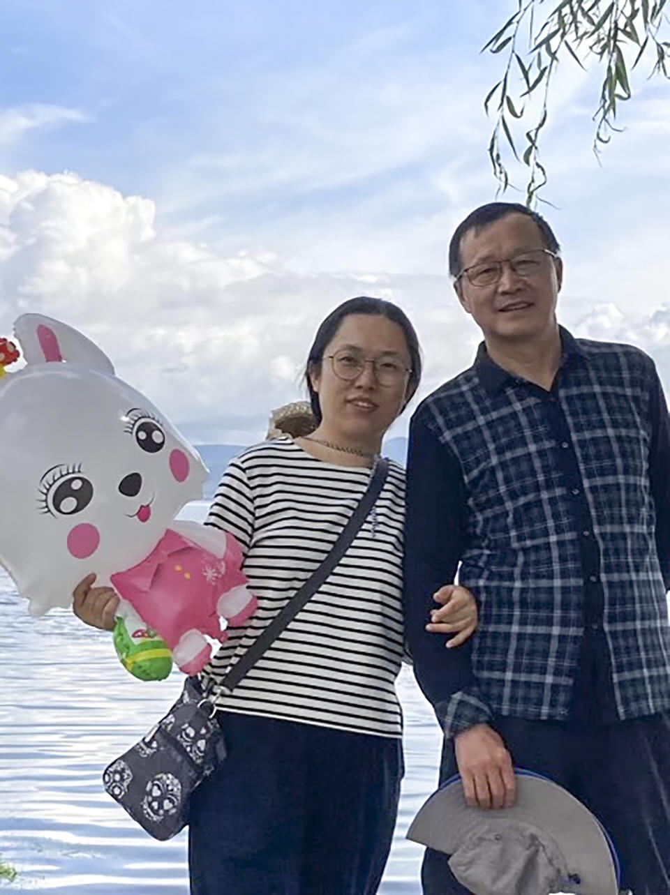 In this Aug. 25, 2023 photo provided by Ge Yunxia, church elder Ding Zhongfu, right, and his wife Ge Yunxia pose for a photo as they visit Dali, in southwestern China's Yunnan province. Ding and four other people, all senior in the Ganquan church were detained by police in November on suspicion of fraud, according to a bulletin from the church. (Ge Yunxia via AP)