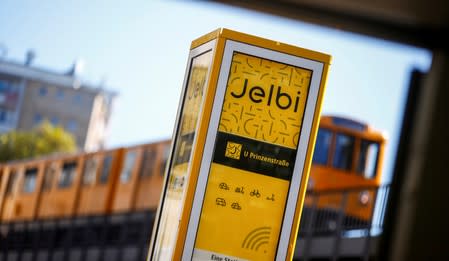 A subway train passes a column of a Jelbi-Station in Berlin