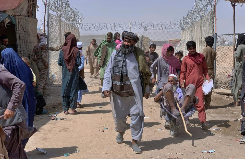 Afghan people enter into Pakistan through a border crossing point, in Chaman, Pakistan, on Aug. 20, 2021. Chaman, is a key border crossing between Pakistan and Afghanistan, normally thousands of Afghans and Pakistanis cross daily and a steady stream of trucks passes through, taking goods to Afghanistan.