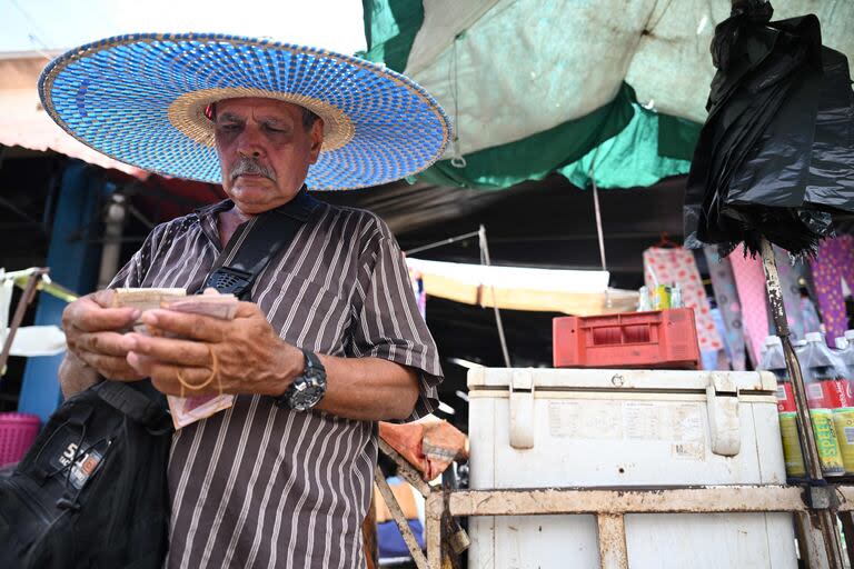 Un hombre cuenta bolívares en un mercado en Maracaibo, estado de Zulia. (Raul ARBOLEDA / AFP)