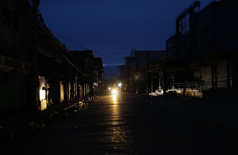 A motorcycle provides light along a dark street after electricity was shut-off following the onslaught of Typhoon Mangkhut in Tuguegarao city in Cagayan province, northeastern Philippines on Saturday, Sept. 15, 2018. The typhoon slammed into the Philippines northeastern coast early Saturday, it's ferocious winds and blinding rain ripping off tin roof sheets and knocking out power, and plowed through the agricultural region at the start of the onslaught. (AP Photo/Aaron Favila)