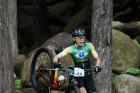 Jaqueline Mourao of Brazilcarries her bike over rocks during the women's cross-country mountain bike competition at the 2020 Summer Olympics, Tuesday, July 27, 2021, in Izu, Japan. (AP Photo/Thibault Camus)