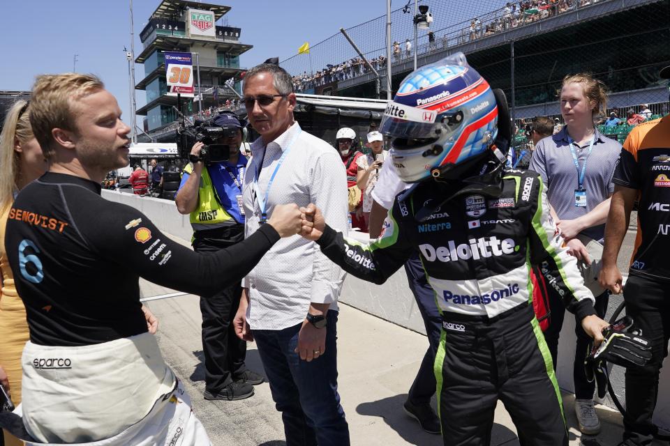 Felix Rosenqvist, left, of Sweden, and Takuma Sato, of Japan, bump fist during qualifications for the Indianapolis 500 auto race at Indianapolis Motor Speedway, Sunday, May 21, 2023, in Indianapolis. (AP Photo/Darron Cummings)