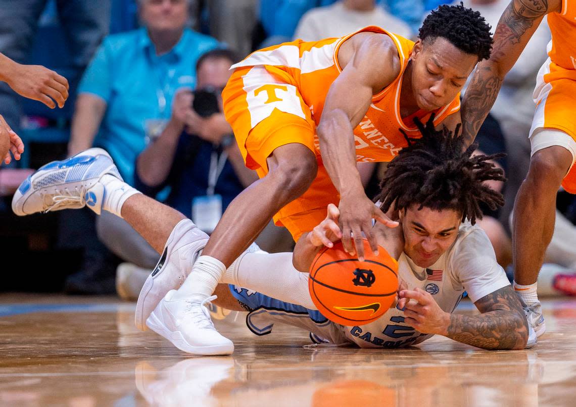 North Carolina’s Elliot Cadeau (2) and Tennessee’s Jonas Aidoo (0) dive to collect a loose ball in the final seconds of play on Wednesday, November 29, 2023 at the Smith Center in. Chapel Hill, N.C. Robert Willett/rwillett@newsobserver.com