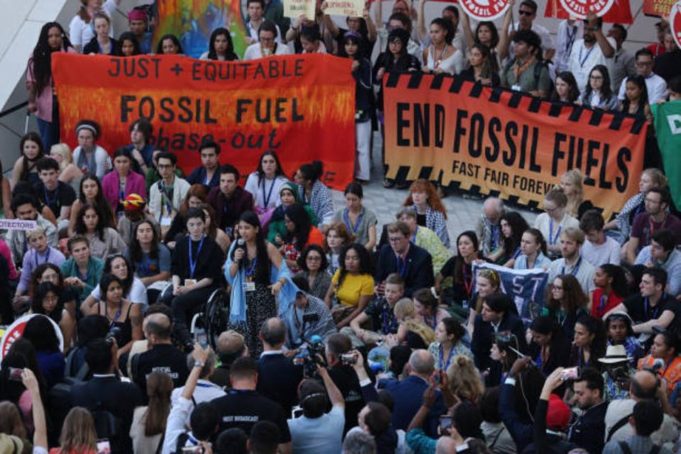 Climate activists protest inside the Dubai Expo venue to demand a phase-out of fossil fuels (Getty Images)
