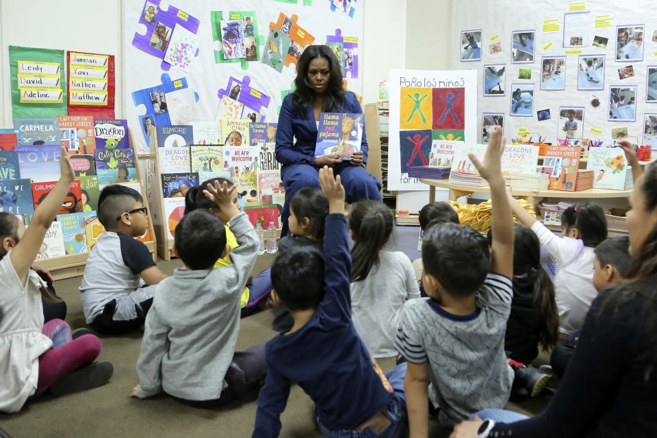Former first lady Michelle Obama reads a book to school children during a surprise appearance at Para Los Niños on Thursday, Nov. 15, 2018, in Los Angeles. (Photo by Willy Sanjuan/Invision/AP)