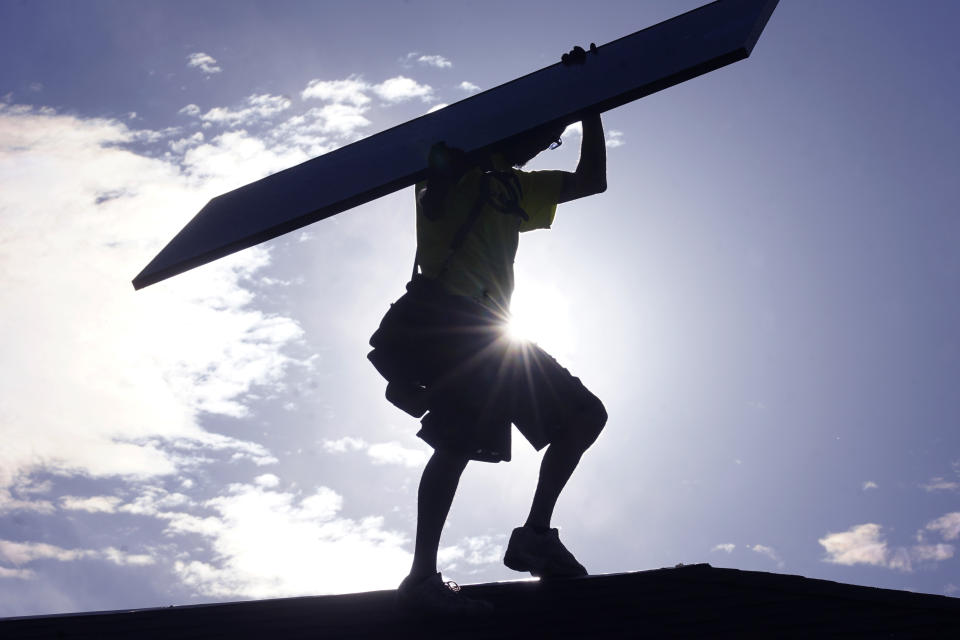 File - A workman installs a solar panel on Thursday, Aug. 11, 2022, in Salt Lake City. Across Europe companies are weighing up the U.S. Inflation Reduction Act's $375 billion in benefits for renewable industries against the European Union's fragmented response. (AP Photo/Rick Bowmer, File)