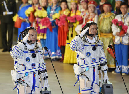 Chinese astronauts Jing Haipeng (L), Chen Dong salute before the launch of Shenzhou-11 manned spacecraft, in Jiuquan, China, October 17, 2016. China Daily/via REUTERS