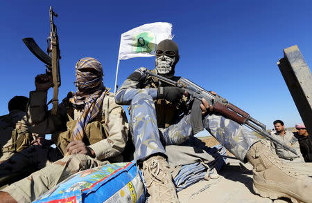 Masked Shi'ite fighters hold their weapons in Al Hadidiya, south of Tikrit, en route to the Islamic State-controlled al-Alam town, Iraq in this March 6, 2015 file photo. REUTERS/Thaier Al-Sudani/Files