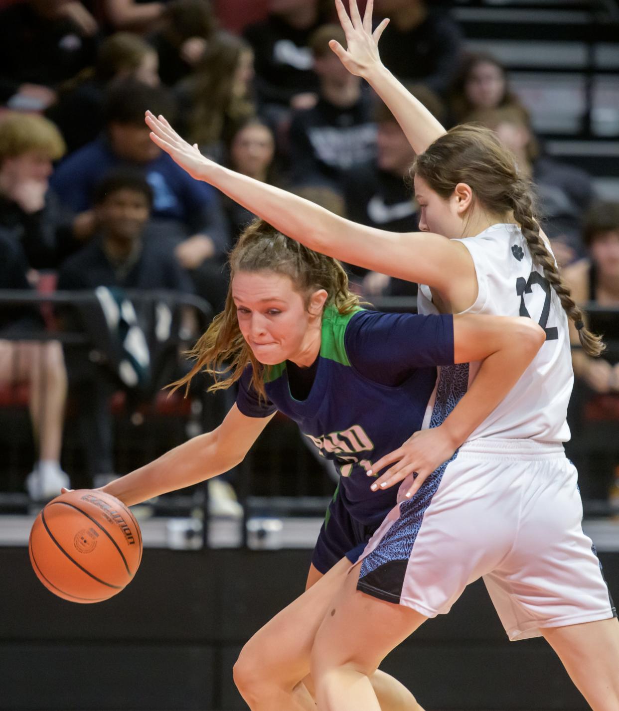 Peoria Notre Dame's Kaitlin Cassidy, left, squeezes by Wilmette Regina Dominican's Natalia Cerrado in the second half of their Class 2A girls basketball state semifinal Thursday, Feb. 29, 2024 at CEFCU Arena in Normal. The Irish routed the Panthers 71-25.