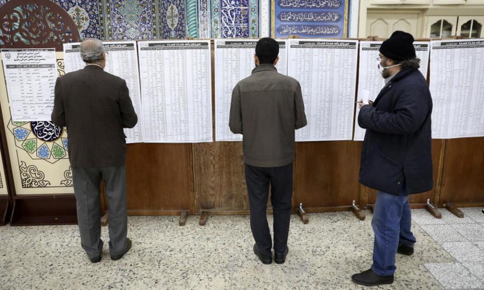 Voters check the dizzying list of the candidates at a polling station in Tehran.