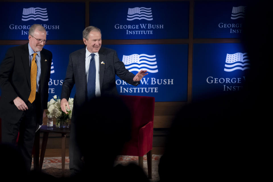 Former President George W. Bush, right, gestures at the audience at the end of his talk with David Kramer, the Executive Director of the George W. Bush Institute, during "The Struggle for Freedom" event at the George W. Bush Presidential Center in Dallas, Wednesday, Nov. 16, 2022. (AP Photo/Emil Lippe)