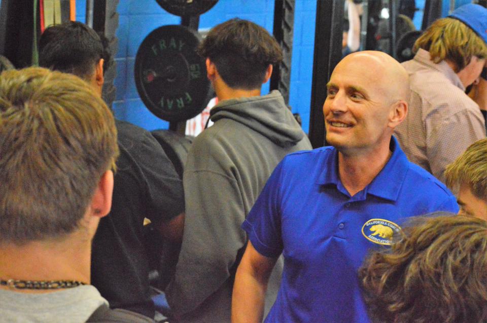 Newly hired Anderson football coach John Stewart (right) talks to potential players at his school's weight room on Thursday, April 28, 2022.