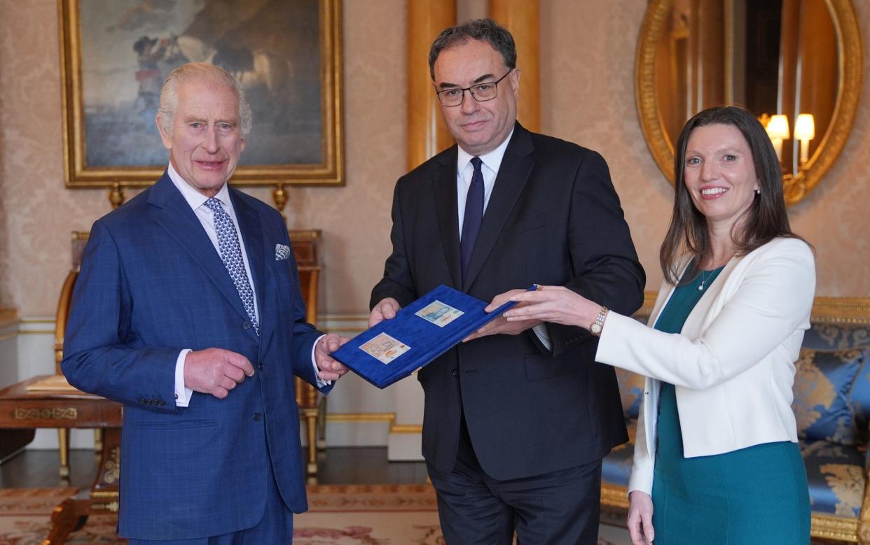 Charles receives the notes in opulent surroundings from the Governor and Chief Cashier of the Bank of England