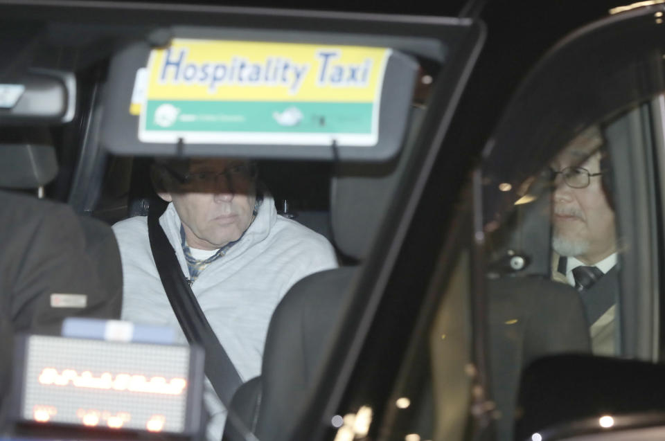 FILE - In this Tuesday, Dec. 25, 2018, file photo, a car carrying Nissan Motor Co.'s executive Greg Kelly, left, leaves Tokyo's Detention Center in Tokyo. The criminal trial against Japanese automaker Nissan and its former executive Greg Kelly will open in Tokyo District Court on Sept. 15. It’s the latest chapter in the unfolding scandal of Carlos Ghosn, a superstar at Nissan Motor Co. until he and Kelly were arrested in late 2018. (AP Photo/Eugene Hoshiko, File)