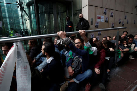 Environmental activists block the entrance of the French bank Societe Generale headquarters during a "civil disobedience action" to urge world leaders to act against climate change, in La Defense near Paris, France, April 19, 2019. REUTERS/Benoit Tessier