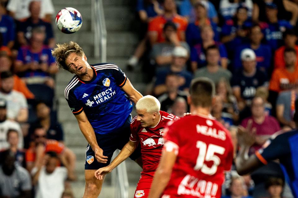 FC Cincinnati defender Nick Hagglund (4) heads the ball as New York Red Bulls defender John Tolkin (47) defends in the first half of the MLS match between FC Cincinnati and New York Red Bulls at TQL Stadium in Cincinnati on Wednesday, Oct. 4, 2023.