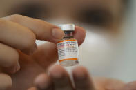 A health worker holds a vial of the Pfizer vaccine for COVID-19 during a vaccination campaign for children at the Hospital da Clinicas in Sao Paulo, Brazil, Friday, Jan. 14, 2022. The state of Sao Paulo started the COVID-19 vaccination of children between ages 5 and 11. (AP Photo/Andre Penner)