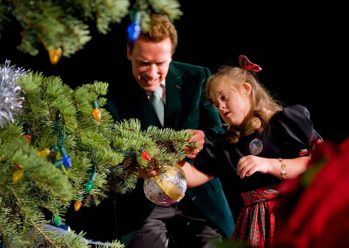 Gov. Arnold Schwarzenegger joins eight-year-old Michaela Tritch of Los Angeles on stage as she places the last ornament on the tree and before lighting the state Capitol Christmas tree in 2008. Brian Baer/Sacramento Bee file