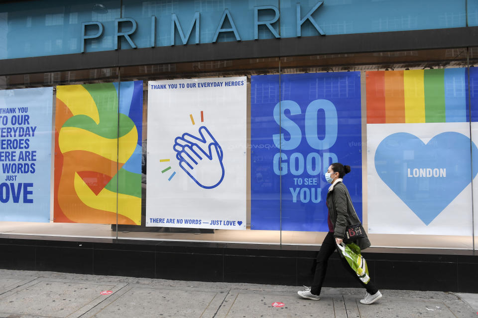 A woman wears a protective mask as she walks past a Primark store in Oxford Street, ahead of the reopening of the non-essential businesses on Monday, June 15, as some of the coronavirus lockdown measures are eased, in London, Friday, June 12, 2020. The British economy shrank by a colossal 20.4% in April, the first full month that the country was in its coronavirus lockdown, official figures showed Friday.(AP Photo/Alberto Pezzali)