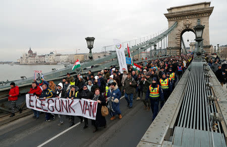 People take part in a protest against a proposed new labor law, billed as the "slave law", on the Chain Bridge in Budapest, Hungary, January 19, 2019. The banner reads "We have had enough". REUTERS/Bernadett Szabo