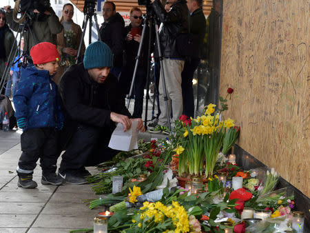 People gathering at the crash site at Ahlens department store following Friday's terror attack in central Stockholm, Sweden, Sunday, April 9, 2017. Jonas Ekstromer/TT News Agency via REUTERS