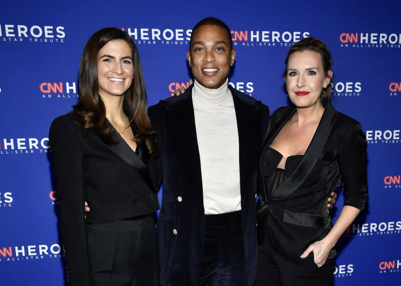 Kaitlan Collins, Don Lemon and Poppy Harlow smile and pose for a photo together in black, formal attire.