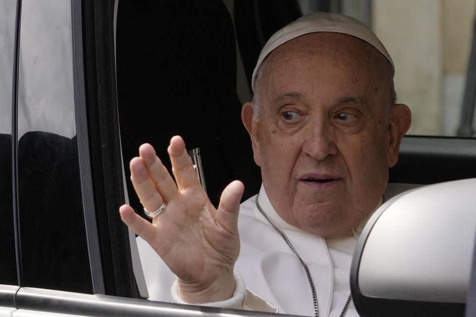 Pope Francis waves from his car as he arrives at The Vatican, Saturday, April 1, 2023, after receiving treatment at the Agostino Gemelli University Hospital for bronchitis, The Vatican said. Francis was hospitalized on Wednesday after his public general audience in St. Peter's Square at The Vatican. (AP Photo/Andrew Medichini)