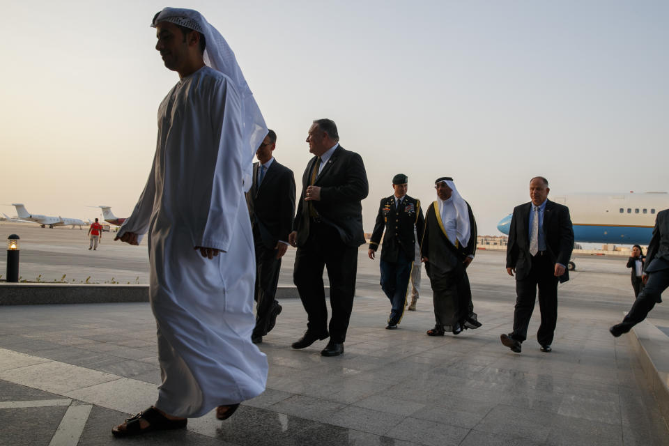 U.S. Secretary of State Mike Pompeo, center, walks with U.S. Charge d'Affaires Steve Bondy, second from left, after being greeted by United Arab Emirates Minister of State Ahmed al-Sayegh, fifth from left, as Pompeo arrives in Abu Dhabi, United Arab Emirates, Monday, June 24, 2019, for talks on Iran. (AP Photo/Jacquelyn Martin, Pool)